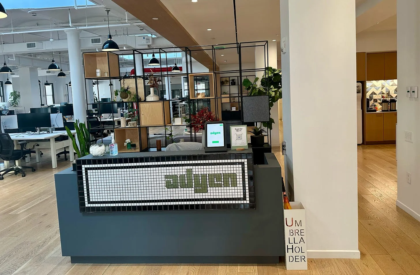 The reception area of the Adyen New York office, with the Adyen logo displayed on the desk.